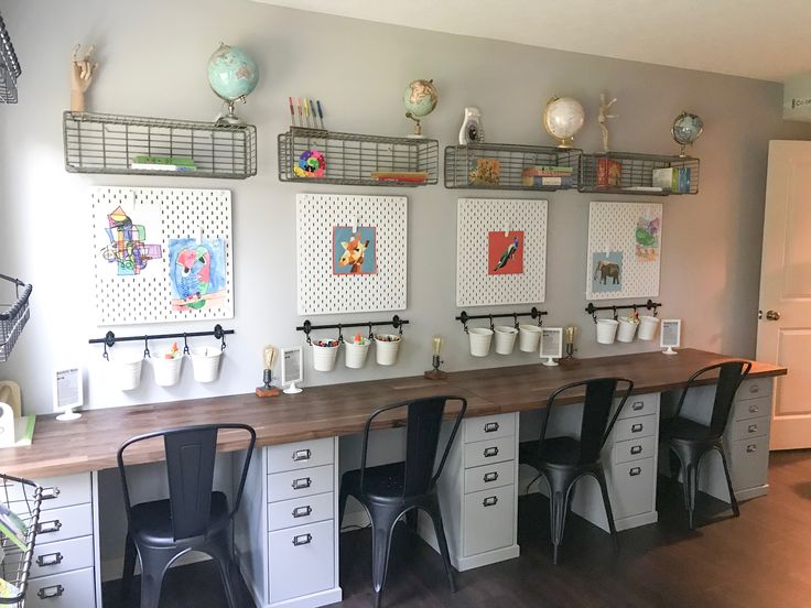 there are many cups on the wall above the desk in this room, and two chairs sit at the counter