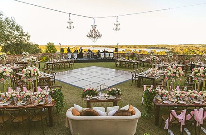 an outdoor reception setup with tables and chairs