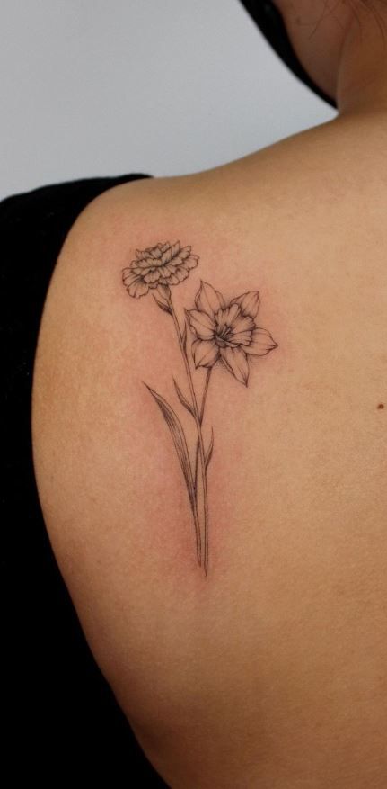 a woman with a tattoo on her shoulder has a flower in the middle of her arm