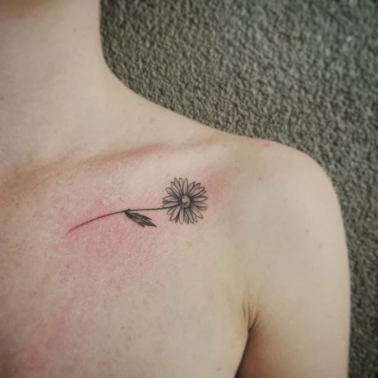 a small flower tattoo on the chest