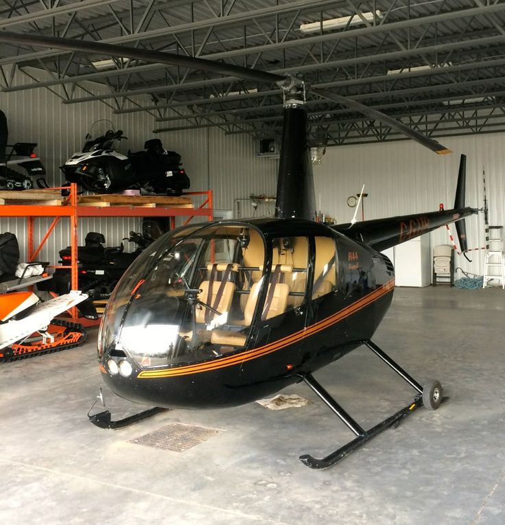 a helicopter is parked in a garage with other vehicles on the shelves and around it