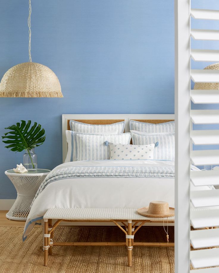 a bedroom with blue walls and white bedding