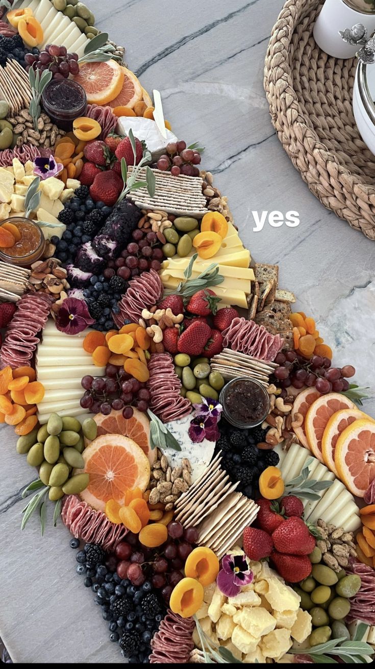 an assortment of cheeses, fruits and nuts arranged in the shape of a triangle