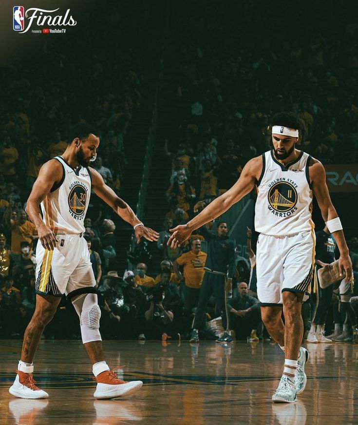 two basketball players shaking hands on the court