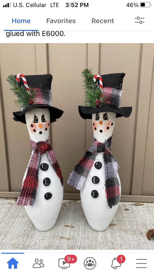 two snowmen with hats and scarfs on their heads are standing next to each other