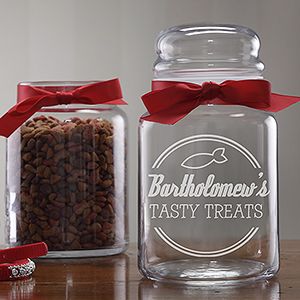 two glass jars filled with treats on top of a table