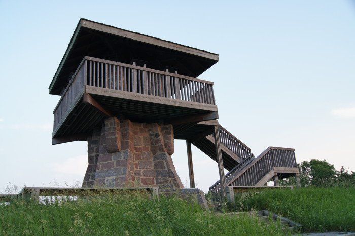 two wooden stairs leading up to the top of a tall structure with a balcony and balconies