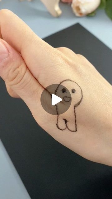 a person's hand with a small dog tattoo on the wrist and thumbnail