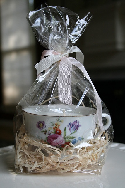 a tea cup in a gift bag on a table