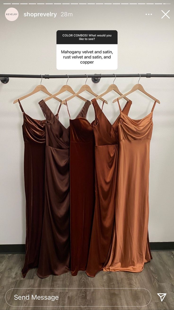 four dresses hanging on a rack in front of a sign