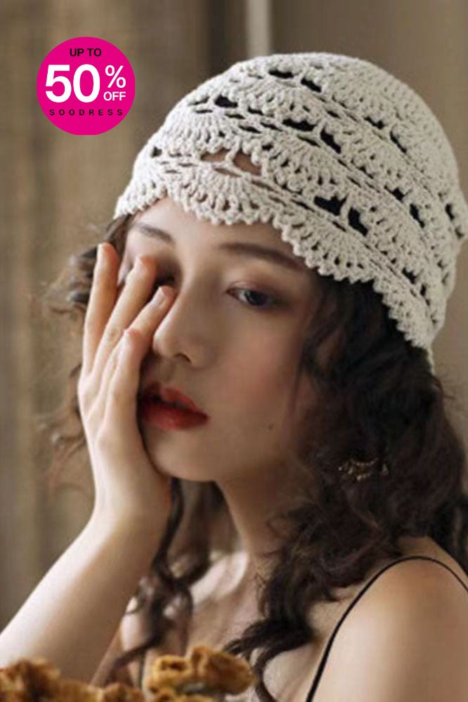 a woman wearing a white crochet headband and holding her hand to her face