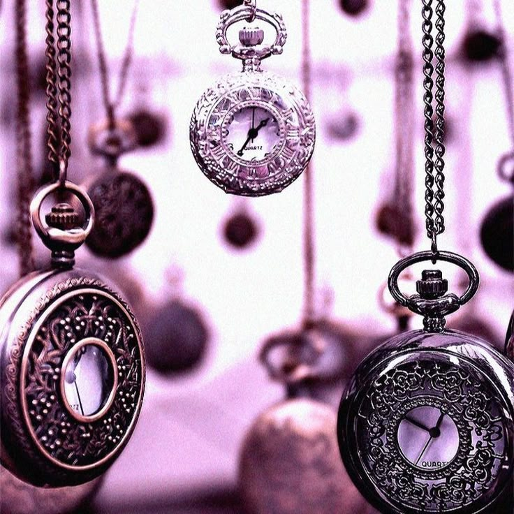 several antique pocket watches hanging from chains