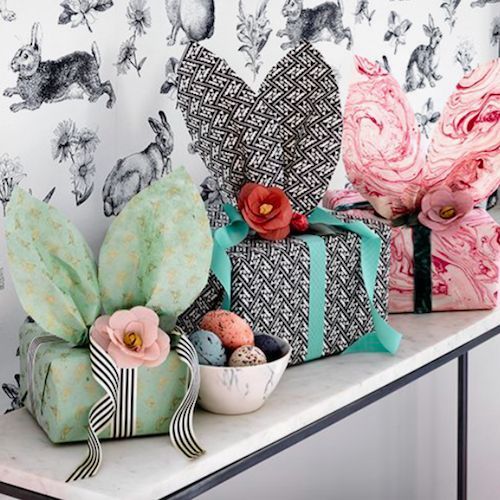 several wrapped presents are sitting on a counter top in front of a wallpapered background