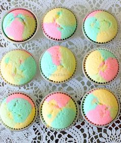 cupcakes with different colored frosting sitting on a doily