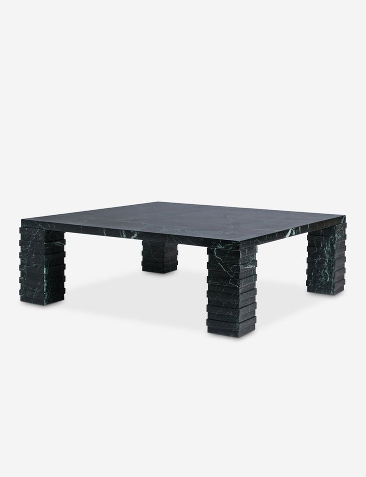 a black marble coffee table with an intricate design on the top and base, against a white background