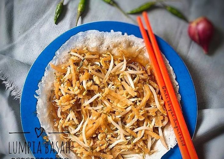 a blue plate topped with food next to chopsticks