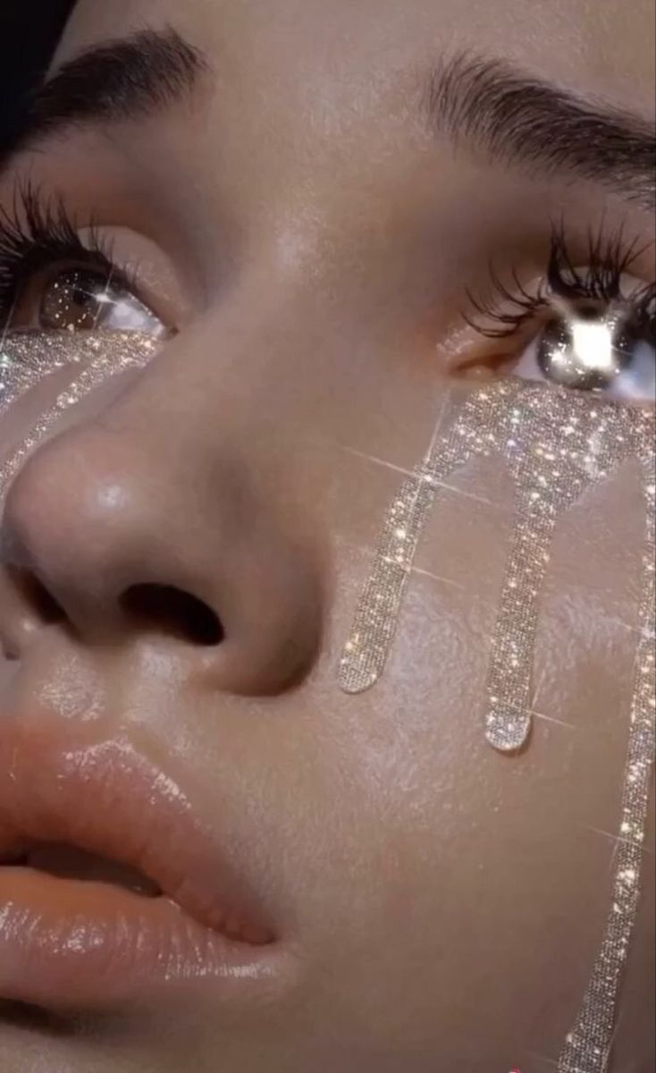 a woman with glitter on her face and eyes