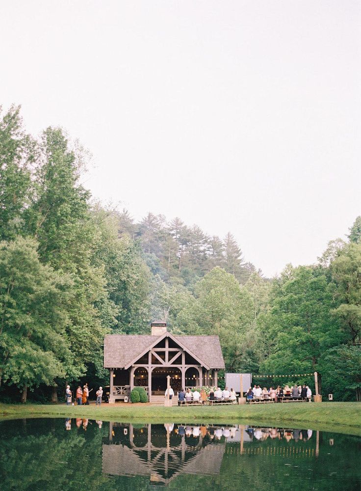 a lake surrounded by lots of trees and people