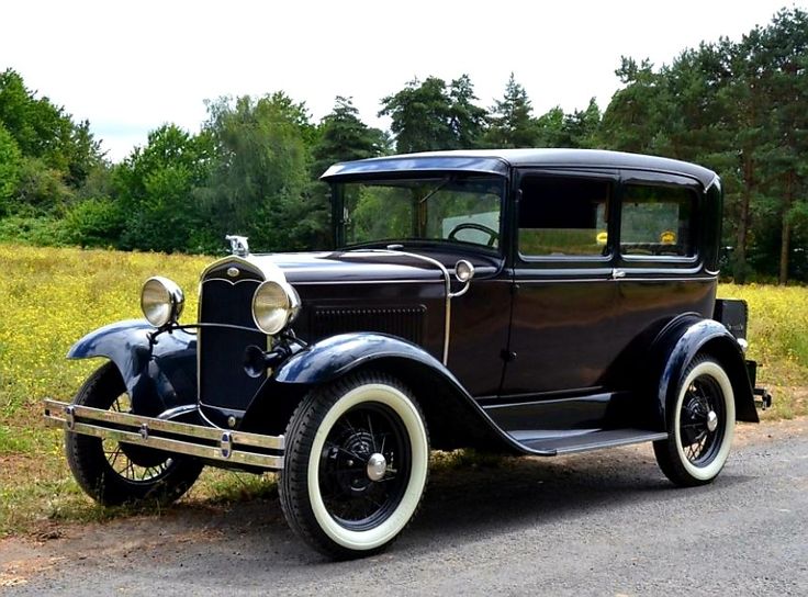 an old car is parked on the side of the road