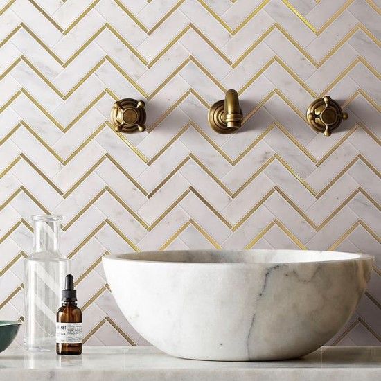 a marble bowl sink sitting on top of a counter next to a wall mounted faucet