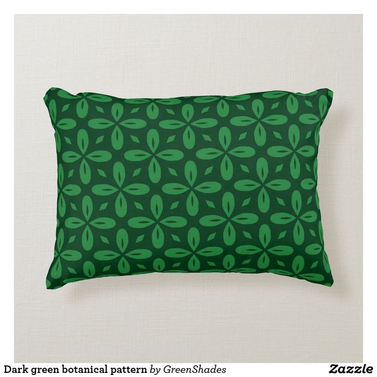 a green pillow with leaves on it is sitting against a white wall and has the words dark green botanical pattern by greensdales