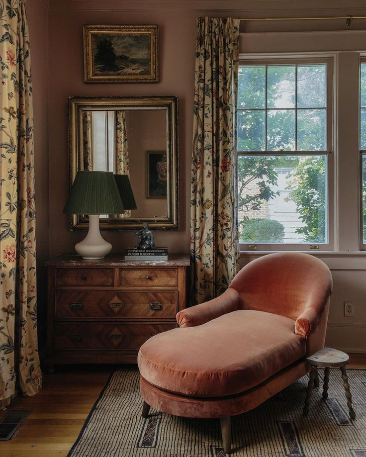 a living room with a chair, mirror and dresser