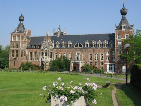 a large building with many windows and flowers in the foreground