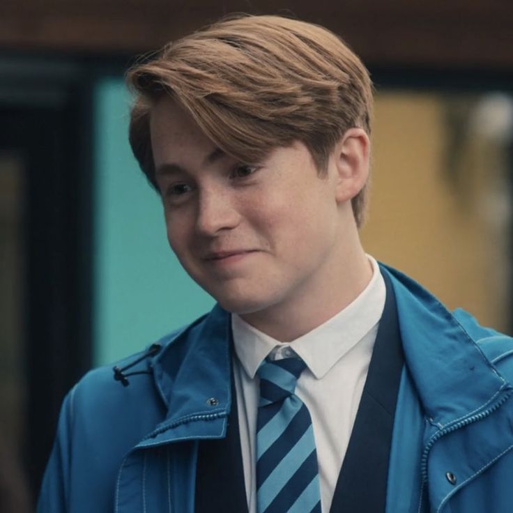 a young man wearing a blue jacket and tie