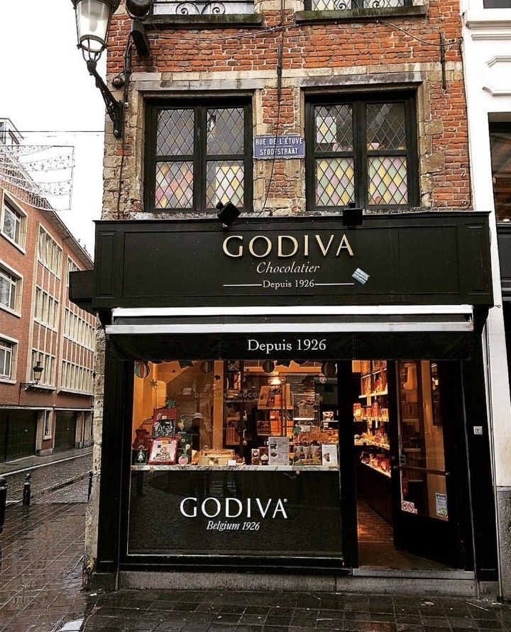 the storefront of godiva in an old european city