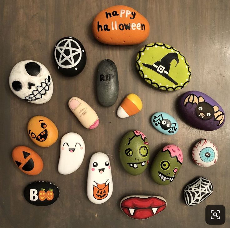 many different colored rocks with faces and words on them, all decorated to look like halloween characters