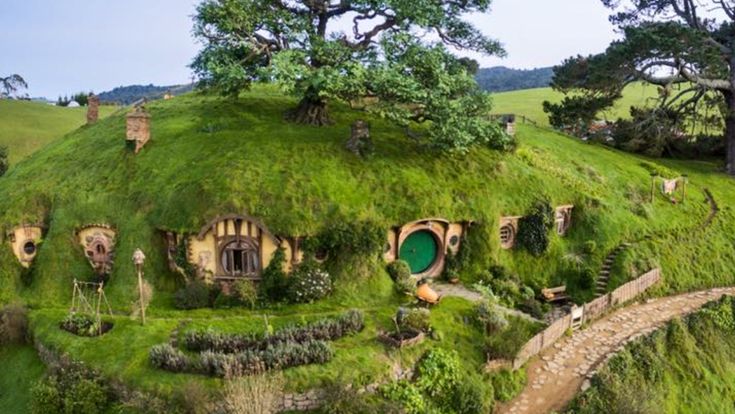 the hobbot house is made out of grass and has trees growing on it