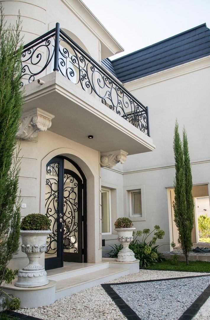 a white house with a black iron balcony