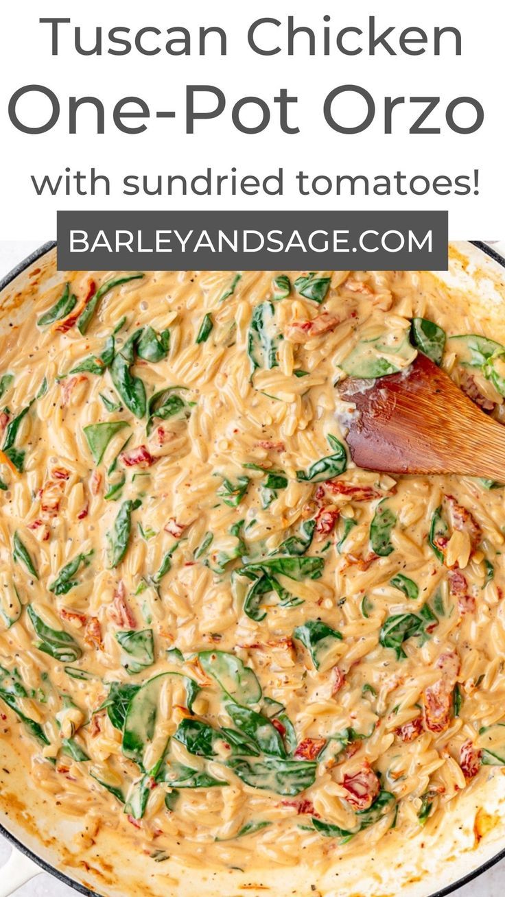 a pot filled with pasta and spinach on top of a table