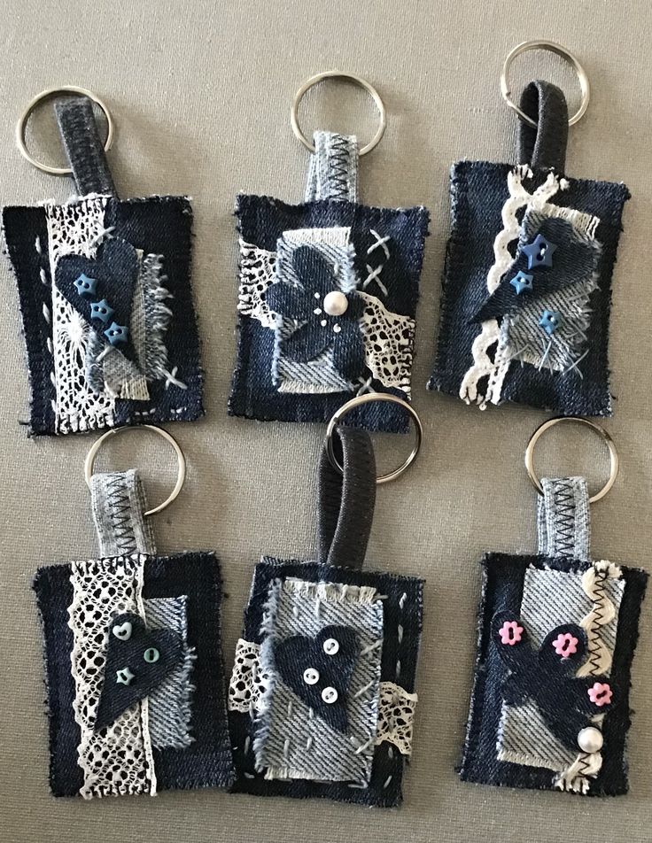 four pieces of fabric with buttons and lace on them are hanging from key chains,