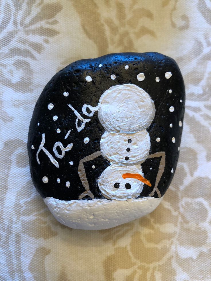 a painted rock with a snowman on it