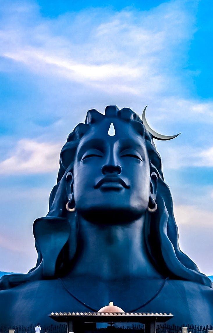 there is a large buddha statue in front of a building with the moon above it