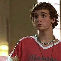 a young man wearing a red shirt and headphones