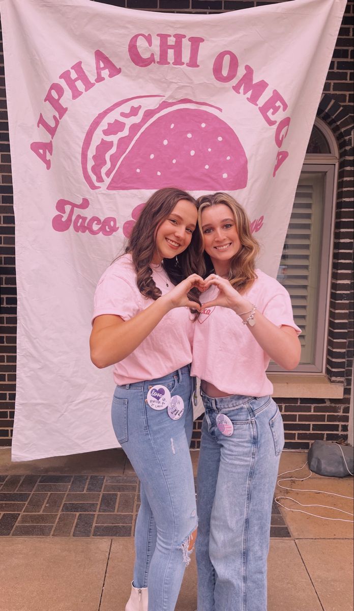 two young women standing next to each other in front of a white banner with the words aloha chi omen on it