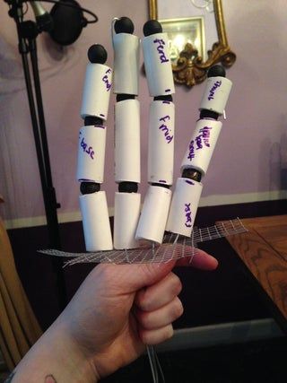 a person holding up some white pens with writing on them