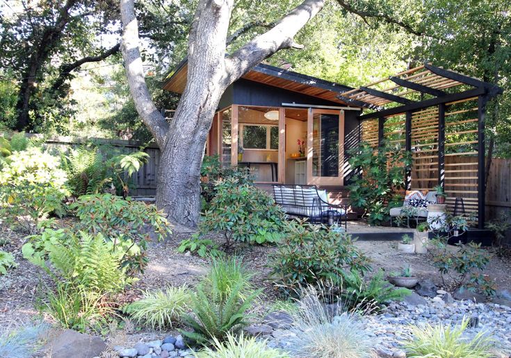 the small cabin is surrounded by greenery and trees