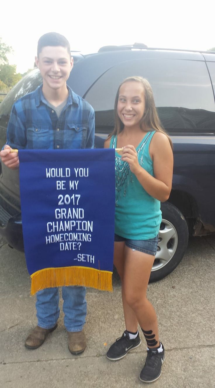 two people standing next to each other holding a sign