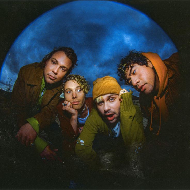 three men are posing in front of a full moon