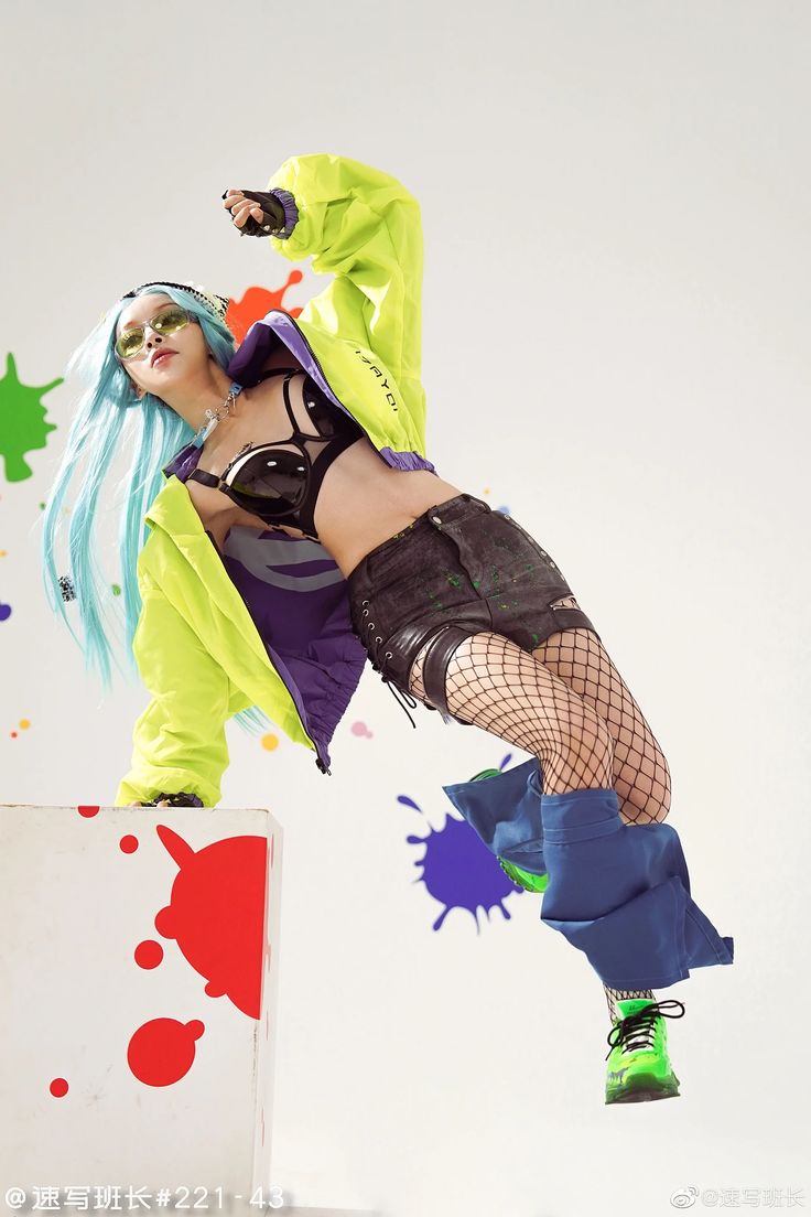 a woman with blue hair is posing on a box