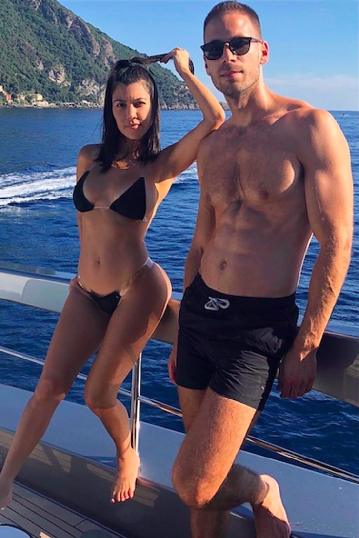 a man and woman on a boat posing for the camera