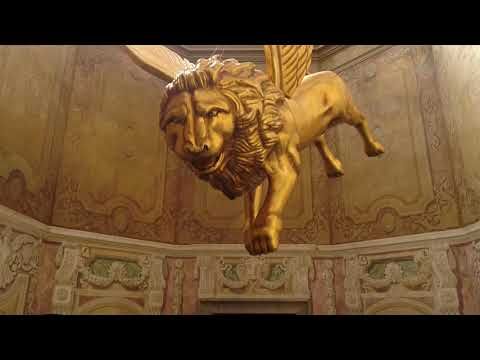 a statue of a lion on top of a wall in a room with gold paint