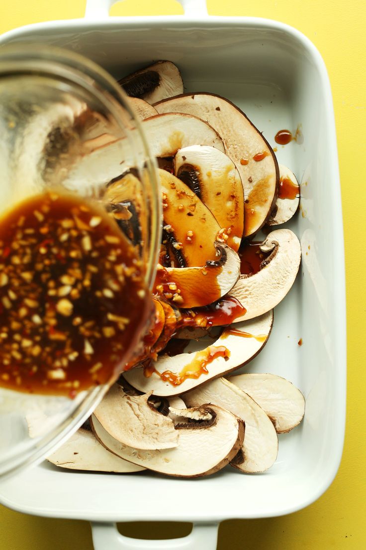 a container filled with sliced mushrooms and sauce