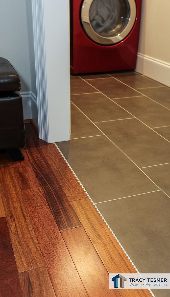 a red washer sitting next to a white door in a room with wood flooring