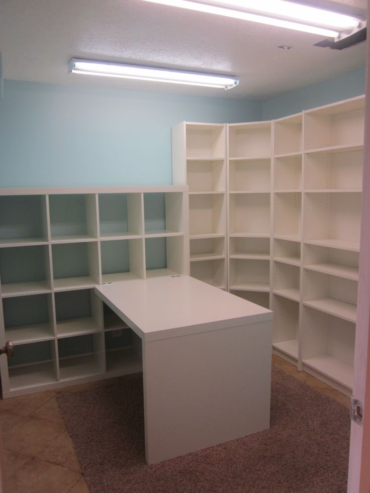 an empty room with white shelving and carpeted flooring in the middle of it