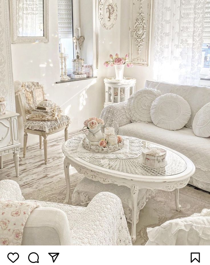 a living room filled with white furniture and flowers in vases on the coffee table