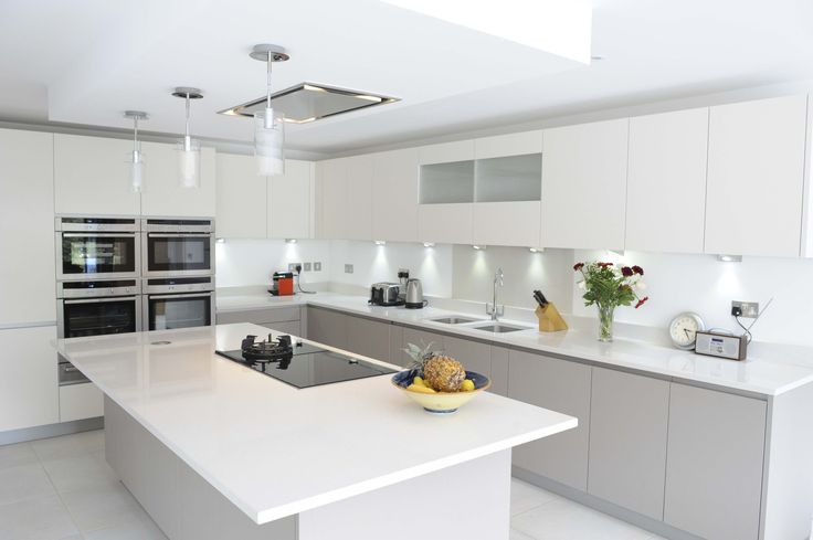 a modern kitchen with white cabinets and stainless steel appliances, including an island countertop